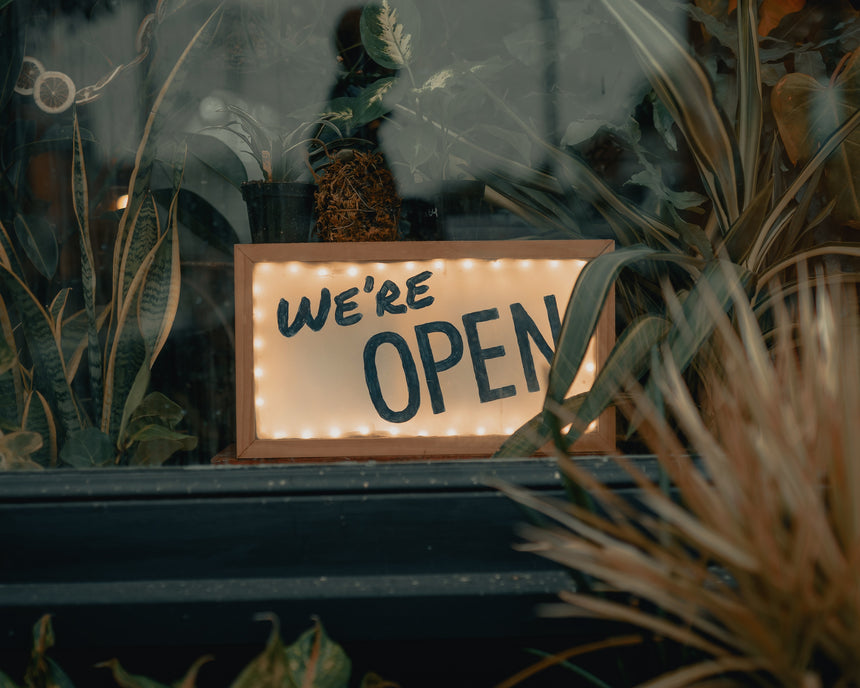 "we're open" sign at shop window 